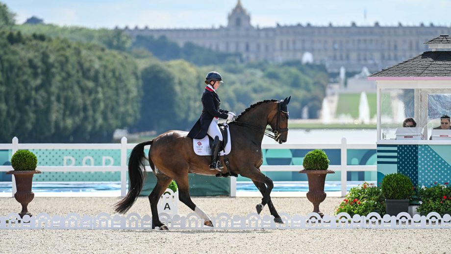 Becky Moody and Jagerbomb in right canter the Olympic dressage arena with the Palace of Versailles behind in the distance