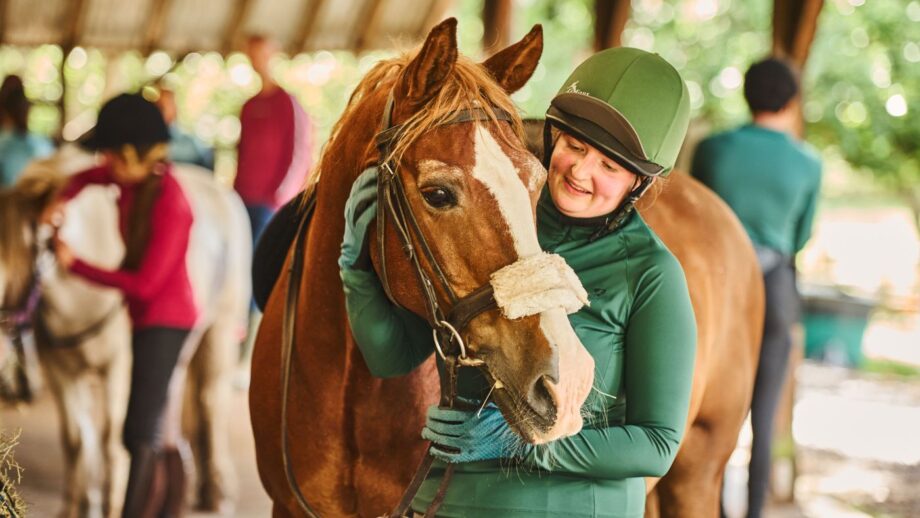 A young woman cuddling a chestnut horse