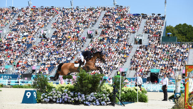 Harry Charles and Romeo 88 clear the open water at the Paris Olympic Games in front of packed stands.