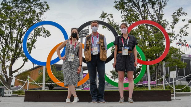 H&H reporter Polly Bryan, photogrpaher Peter Nixon and H&H reporter Pippa Roome picturesd wearing face masks standing in front of the Olympic ring at the Tokyo Games.