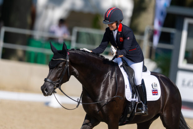 Sophie Wells pats LJT Egebjerggards Samoa on the neck as the mare wals out of the arena at the 2023 European Championships on a loose rein.